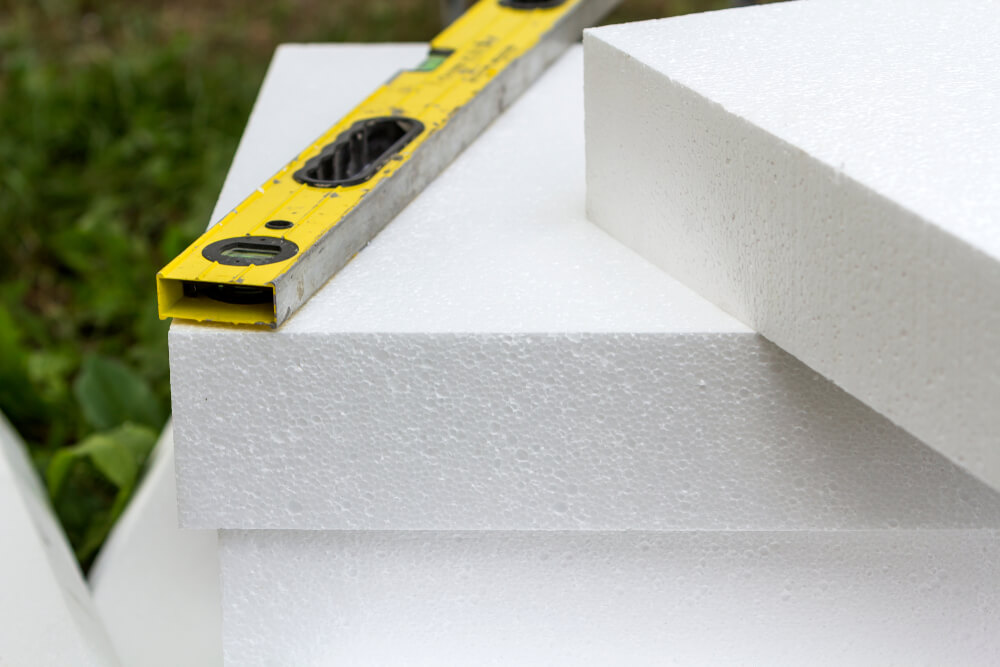 Close-up Detail of Stack of White Rigid Polyurethane Foam Sheets for House Insulation and Level