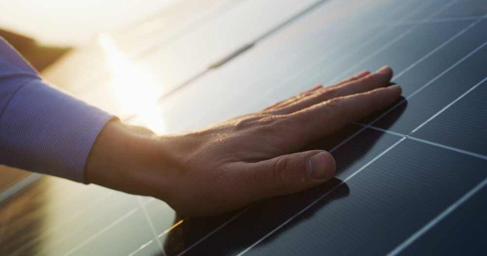 Close Up of an Young Engineer Hand Is Checking an Operation of Sun and Cleanliness of Photovoltaic Solar Panels on a Sunset