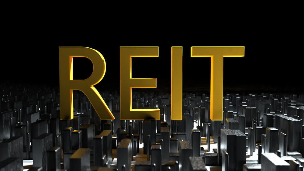 Concept Image of Business Acronym REIT as Real Estate Investment Trust Written Over Road Marking Yellow Painted Line